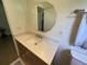 Bathroom featuring a modern vanity with light countertops, decorative mirror, and updated fixtures and hardware at 427 Longfellow Blvd, Lakeland, FL 33801