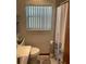 Standard bathroom featuring toilet, towel rack, window with blinds, and shower with floral curtain at 427 Longfellow Blvd, Lakeland, FL 33801