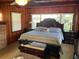 Cozy bedroom with wood paneling, a ceiling fan, and a comfortable king-size bed at 427 Longfellow Blvd, Lakeland, FL 33801
