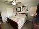 A cozy bedroom featuring hardwood floors, a ceiling fan, and framed artwork above the bed at 427 Longfellow Blvd, Lakeland, FL 33801