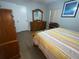 Bright bedroom features wood flooring and dresser, a large closet, and artwork at 427 Longfellow Blvd, Lakeland, FL 33801