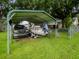Boat and truck parked under a large metal carport structure on a grassy lot at 427 Longfellow Blvd, Lakeland, FL 33801