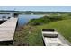 The wood dock leads to the lake, with a small metal boat sitting on the lawn near the water at 427 Longfellow Blvd, Lakeland, FL 33801