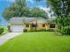 Charming single-story home with a lush green lawn and a white two-car garage at 427 Longfellow Blvd, Lakeland, FL 33801