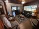 Spacious living room with multiple seating areas, wood paneling, and abundant natural light at 427 Longfellow Blvd, Lakeland, FL 33801