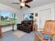 Cozy living room with a ceiling fan, large windows, and a comfortable leather sofa at 427 Longfellow Blvd, Lakeland, FL 33801