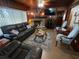 Inviting living room featuring wood paneling, fireplace and comfortable sofas and chairs at 427 Longfellow Blvd, Lakeland, FL 33801