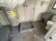 Utility room featuring a water heater, utility sink, toilet, and floor drain for practical household needs at 427 Longfellow Blvd, Lakeland, FL 33801