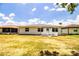 View of the house's back exterior with a grassy lawn and a small fence at 4976 Pleasant Hollow Trl, Lakeland, FL 33811