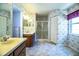 Spacious bathroom with double sinks, glass shower, and wallpaper with doorway to a bedroom at 4976 Pleasant Hollow Trl, Lakeland, FL 33811