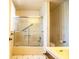 Bathroom featuring a bathtub with glass doors, toilet, and a vanity with a yellow sink at 4976 Pleasant Hollow Trl, Lakeland, FL 33811