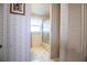 Hallway view of a vintage bathroom including a vanity, shower/tub, and a window with floral wallpaper at 4976 Pleasant Hollow Trl, Lakeland, FL 33811