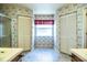 Spacious bathroom with double sinks, shower, and closet with patterned wallpaper at 4976 Pleasant Hollow Trl, Lakeland, FL 33811