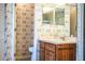 Bathroom featuring a sink, wooden cabinets, and toilet with patterned wallpaper at 4976 Pleasant Hollow Trl, Lakeland, FL 33811