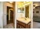 Bathroom with vintage-inspired floral wallpaper, vanity with a mirrored medicine cabinet, and doorway to another room at 4976 Pleasant Hollow Trl, Lakeland, FL 33811