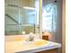 Bathroom vanity and sink with chrome faucet, and a glass-enclosed shower with a window visible in the mirror at 4976 Pleasant Hollow Trl, Lakeland, FL 33811