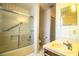 Bathroom featuring a bathtub with glass doors, patterned wallpaper, and vanity with sink at 4976 Pleasant Hollow Trl, Lakeland, FL 33811