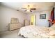 Bright bedroom featuring floral comforter, ceiling fan and bathroom entrance at 4976 Pleasant Hollow Trl, Lakeland, FL 33811