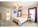 Cozy bedroom with floral bedding, a ceiling fan, and ample natural light at 4976 Pleasant Hollow Trl, Lakeland, FL 33811