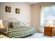 Cozy bedroom showcases a daybed with green striped bedding and a window with blinds at 4976 Pleasant Hollow Trl, Lakeland, FL 33811