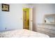 Bright bedroom featuring white walls, white dresser, and a door leading to another room at 4976 Pleasant Hollow Trl, Lakeland, FL 33811