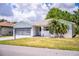 Charming single Gathering home with a well-maintained lawn, a beautiful palm tree, and a screened-in garage at 4976 Pleasant Hollow Trl, Lakeland, FL 33811