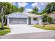 Charming single-story home featuring a screened garage, well-maintained lawn, and mature trees at 4976 Pleasant Hollow Trl, Lakeland, FL 33811