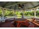 Inviting gazebo featuring a large picnic table and benches, offering a picturesque lakeside view for relaxing and dining at 4976 Pleasant Hollow Trl, Lakeland, FL 33811