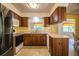 Well-lit kitchen features wood cabinets, white appliances, and tiled floor at 4976 Pleasant Hollow Trl, Lakeland, FL 33811