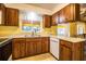 Classic kitchen featuring wood cabinets, cream counters, and tile flooring at 4976 Pleasant Hollow Trl, Lakeland, FL 33811