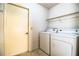 Laundry room with a washer and dryer, a door, overhead shelving, and tile floors at 4976 Pleasant Hollow Trl, Lakeland, FL 33811