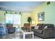 Comfortable living room with tiled floors, two recliners, a couch and natural light at 4976 Pleasant Hollow Trl, Lakeland, FL 33811
