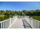Scenic view of a tranquil lake from a wooden pier with seating, perfect for relaxing by the water at 4976 Pleasant Hollow Trl, Lakeland, FL 33811