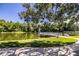 Picturesque lake view from a grassy lawn with a fountain and a charming wooden pier at 4976 Pleasant Hollow Trl, Lakeland, FL 33811