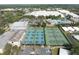 Aerial view of tennis courts, pool, and sports complex surrounded by green spaces and parking at 502 Duchess Dr, Lakeland, FL 33803