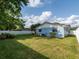 Large backyard with lush green grass, mature trees, and a white privacy fence at 502 Duchess Dr, Lakeland, FL 33803