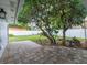 Serene backyard with a brick patio surrounded by lush trees and a white fence at 502 Duchess Dr, Lakeland, FL 33803