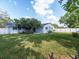 Expansive backyard with a well-maintained lawn, shade trees, and a charming blue home at 502 Duchess Dr, Lakeland, FL 33803