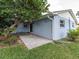 Backyard with paver patio, blue house, and green lawn at 502 Duchess Dr, Lakeland, FL 33803
