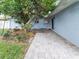Backyard patio with mature tree, garden, and blue house wall at 502 Duchess Dr, Lakeland, FL 33803