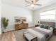A modern bedroom featuring neutral colors, a ceiling fan, and a decorative plant near a sunlit window at 502 Duchess Dr, Lakeland, FL 33803