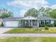 Charming single-story home with a well-manicured lawn, mature trees, and an attached two-car garage at 502 Duchess Dr, Lakeland, FL 33803