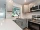 Modern kitchen with bright countertops, updated cabinets, stainless steel appliances, and a garden window at 502 Duchess Dr, Lakeland, FL 33803