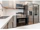 Modern kitchen featuring stainless steel appliances, gray cabinets, and white quartz countertops at 502 Duchess Dr, Lakeland, FL 33803