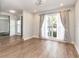 Bright living room with wood flooring, large window with curtains, and access to other areas of the home at 502 Duchess Dr, Lakeland, FL 33803