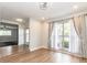 Bright living room with wood flooring, large window with curtains, and access to other areas of the home at 502 Duchess Dr, Lakeland, FL 33803
