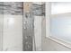 Shower featuring a multi-setting shower panel and tiled walls with glass mosaic accents at 502 Duchess Dr, Lakeland, FL 33803