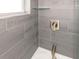 Close up of a tiled shower with gray wood-like tiles and a glass shelf at 502 Duchess Dr, Lakeland, FL 33803