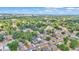 An aerial view showcases houses amidst dense greenery near a distant skyline and a large body of water at 523 W Hancock St, Lakeland, FL 33803