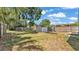 A fenced backyard featuring an outdoor storage shed, landscaping, and a mix of grass and weeds at 523 W Hancock St, Lakeland, FL 33803